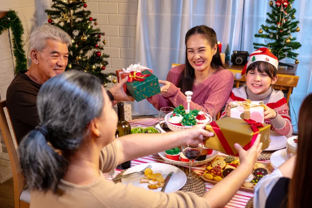 Happy family exchanging gifts around a dining room table